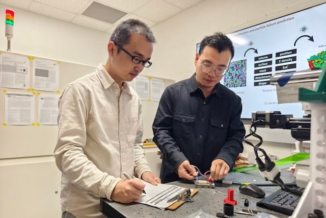 Researchers Guannan Qian, left, and Tianxio Sun investigate battery performance in a laboratory at the Cockrell School of Engineering’s Walker Department of Mechanical Engineering