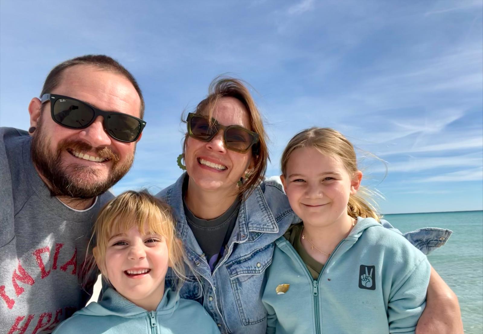 Sarah Reed on the beach with her husband Austin and her daughters Vera and Isla
