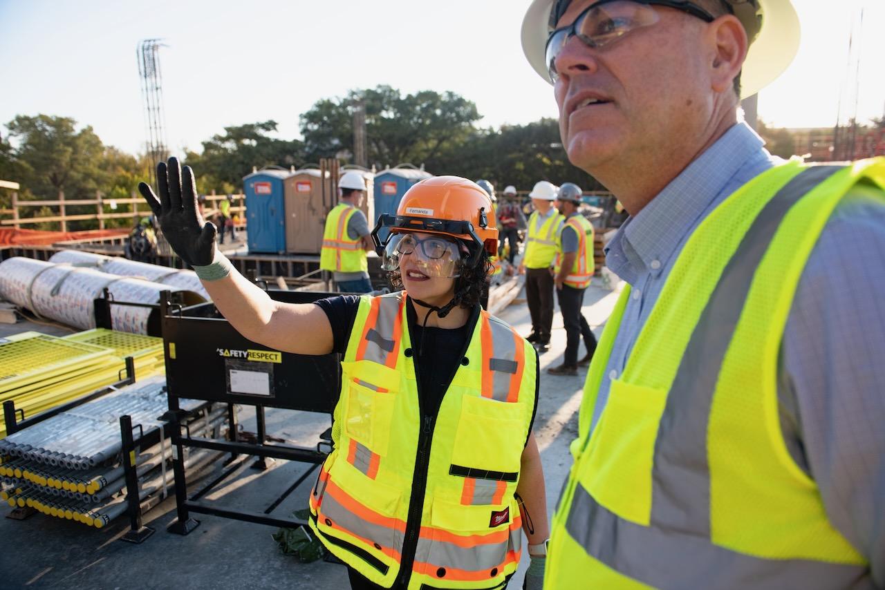 Dr. Fernanda Leite, Vice President for Research at The University of Texas at Austin, gestures while speaking at an active construction site.